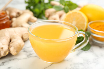 Immunity boosting drink and ingredients on white marble table, closeup