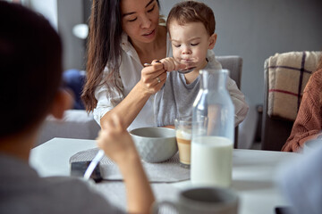 Cheerful happy family is having time at cozy home's dining room