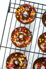 chocolate sprinkle donuts on wire rack