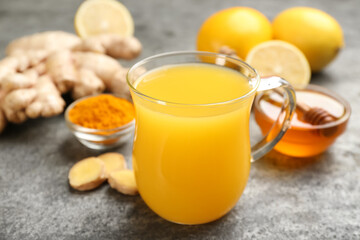 Immunity boosting drink and ingredients on grey table, closeup