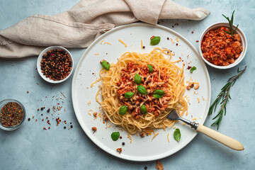 Delicious dish with spaghetti and meat bolognese sauce on a gray-blue background. The view from the top. The concept of cooking.