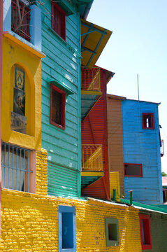 Buenos Aires, Argentina - 01/07/2012: La Boca area. Corrugated facades are painted in different colors, and window and door frames are in opposite colors under a silvery sky.
