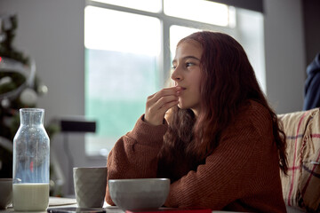 Young beautiful caucasian girl is eating breakfast