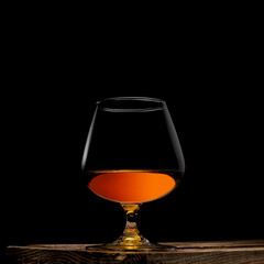 a glass of whisky with wooden box on black background