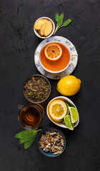 Green and herbal tea with lemon, ginger,lime and sage on a dark  background, top view. Healthy detox drink. Flat lay.