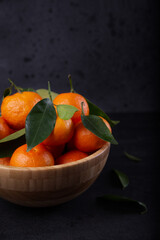 Freshly harvested tangerines from organic farming exposed on dark background.