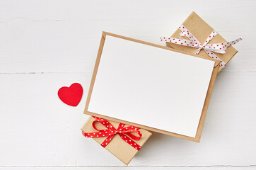 Valentines day greeting card mockup and gift boxes on white wooden background