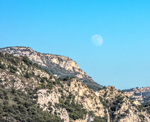 La pleine lune appara&icirc;t en plein jour au-dessus de la montagne