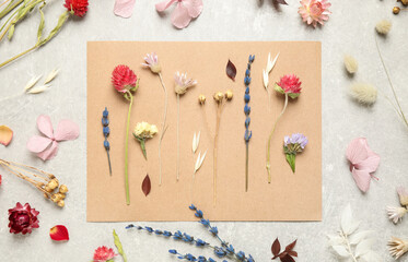 Fototapeta na wymiar Flat lay composition with beautiful fresh and dry flowers on light grey background