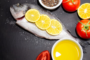 Fototapeta na wymiar Raw dorado fish on a black slate board to prepare for cooking.