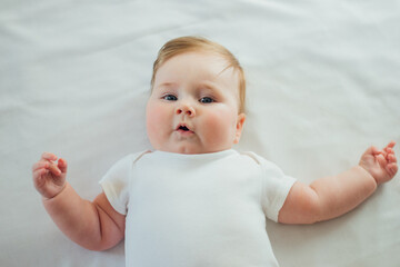 Cute infant baby lying on white sheets