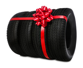 Winter tires with red ribbon on white background