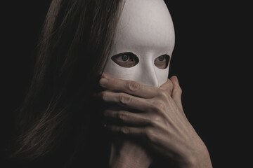 portrait of a woman in a white mask in the dark