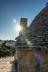 Sunshine on summer vacation in trulli town of Alberobello in Puglia, Italy