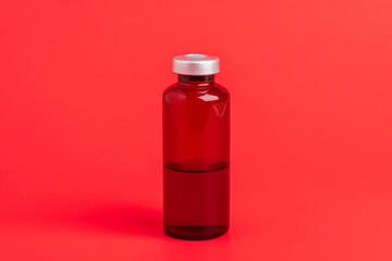 Macro Image Of Amber Vaccine Vial Set On Red Background