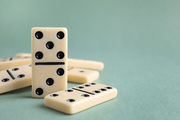 Classic domino tiles on grey background, closeup. Space for text