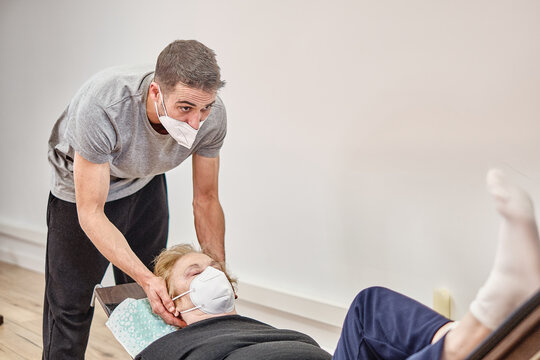 Yoga instructor helping old woman with a yoga exercise - Powered by Adobe