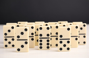 Domino tiles on wooden table against black background