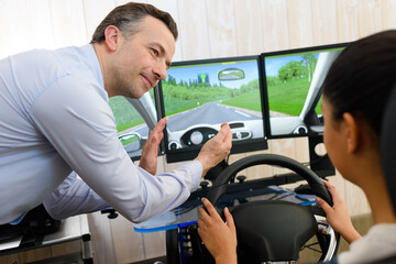 driving student being assisted in driving on a simulator