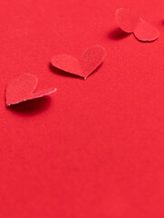 Red paper hearts on a red background. Valentine's Day.