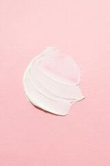Cosmetic, smear, mask, cream. For care skin. A light cream smear on a pink background.
