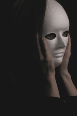 portrait of a woman in a white mask in the dark