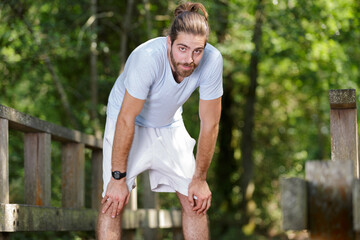 portrait of young man catching his breath after exercising