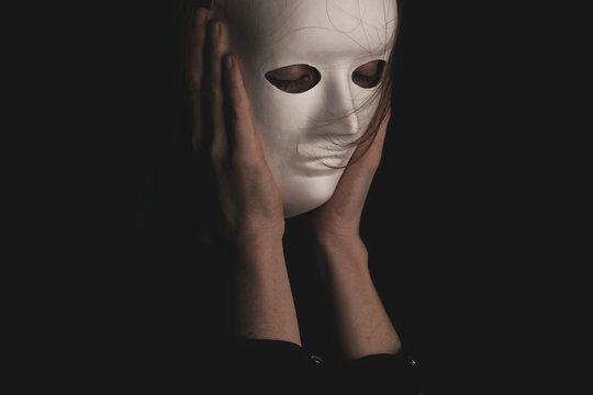 portrait of a woman in a white mask in the dark.