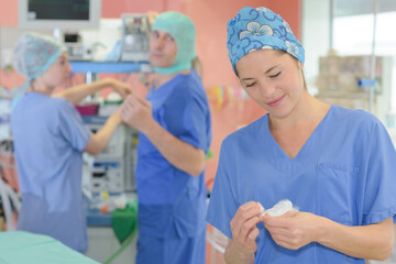 nurse in scrubs preparing for operation in hospital theatre