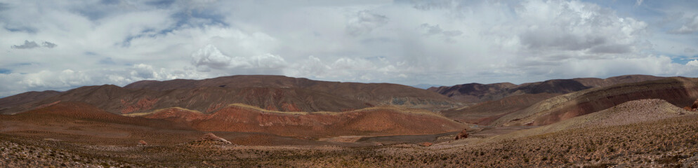 The arid desert. Altiplano. Panorama view of the dry land, valley and colorful mountains under a beautiful sky.