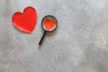 red heart and magnifying on a white background