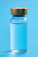 Dose of lifesaving medication, immunization science and healing chemical concept with picture of one singe glass vial of vaccine isolated on blue background with clipping path cutout