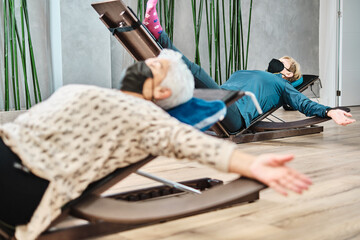 Old women lying down doing yoga exercises in a physiotherapy