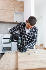 The carpenter finalizing the assembly of the kitchen shelf