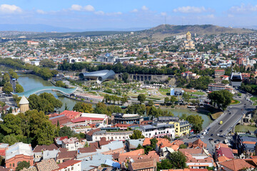Fototapeta na wymiar Tbilisi, Georgia overview. Modern landmarks of the city visible including the Bridge of Peace over Kura River, Rike Park and Presidential Palace.