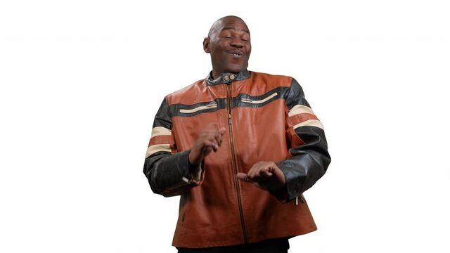 Handsome black man wearing a leather jacket dances and laughs on a white background