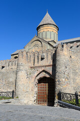 Fototapeta na wymiar Vertical photo of Svetitskhoveli Cathedral from outside the wall gate. Orthodox Christian church located in Mtskheta, Georgia in the Caucasus.