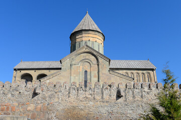 Fototapeta na wymiar Lateral view of Svetitskhoveli Cathedral, located in Mtskheta, Georgia in the Caucasus. Orthodox Christian church with wall in front. World Heritage.