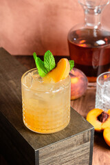 peach whiskey cocktail on wood table
