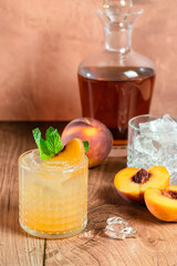 peach whiskey cocktail on wood table