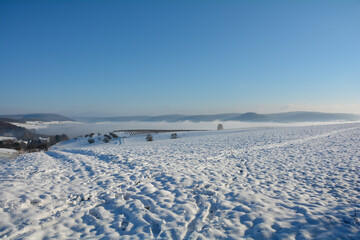 Fototapeta na wymiar Snow landscape with fields and fog and sky