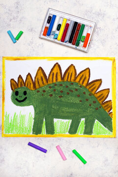 Photo of colorful drawing: Smiling dinosaur. Green weird stegosaurus.