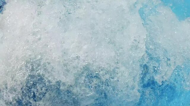 Big bubbles in warm water in a jacuzzi pool slow motion in resort luxury hotel. Hydroterrapy. Strong water pressure in the spa salon. The texture of boiling water. Relax. Tourism. Family