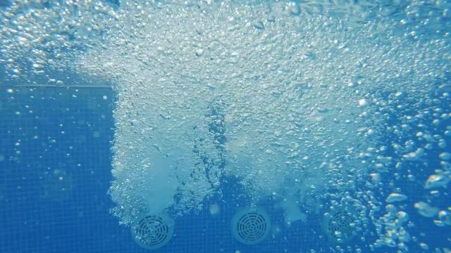 Big bubbles in warm water in a jacuzzi pool slow motion in resort luxury hotel. Hydroterrapy. Strong water pressure in the spa salon. The texture of boiling water. Relax. Tourism. Family
