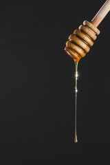 honey dripping from a wooden dipper