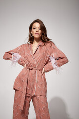 Pretty sexy woman beautiful face natural makeup brunette hair wear silk textile suit pants and...