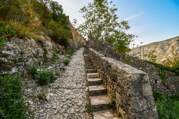 Fototapeta na wymiar The ancient stone pathway and steps to the medieval St. John's fortress in the mountains above the city of Kotor, Montenegro.