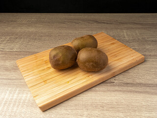 golden kiwi whole and slices on wooden table