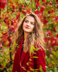 Beautiful happy smiling girl with long hair, posing in autumn street. Close up outdoor portrait. Female fashion concept