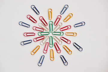 白い紙の上にたくさんのカラフルなクリップ